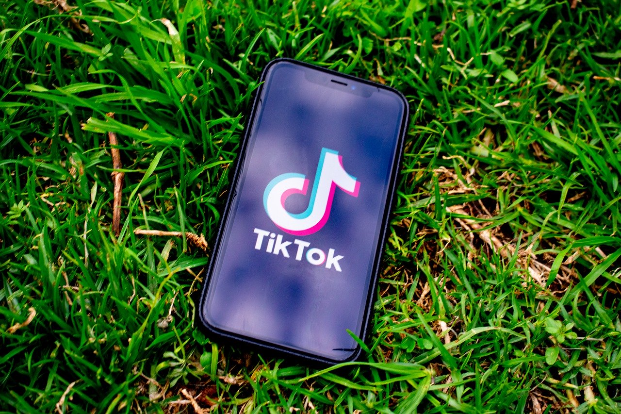 Phone displaying TikTok laying in grass